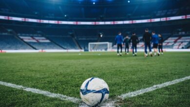 ملعب كرة قدم فارغ مع أعلام وأجواء مباراة دولية ترمز لمنتخب إنجلترا