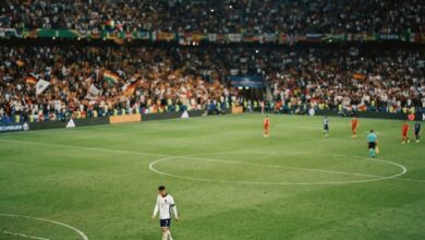 لاعب كرة قدم يرتدي قميص منتخب وطني في أرضية الملعب خلال مباراة دولية